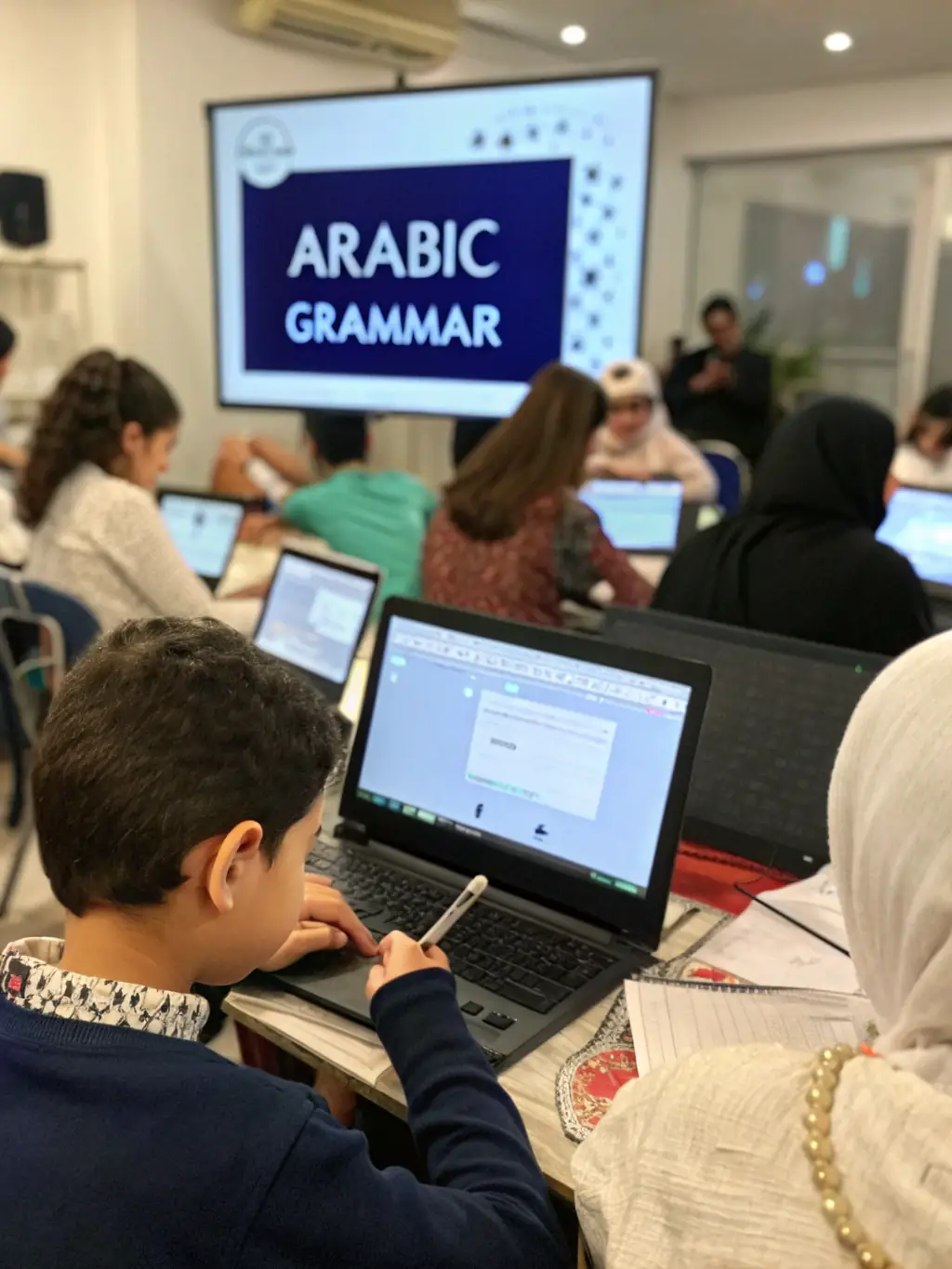 A vibrant image of a classroom setting with students actively participating in an Arabic lesson, focusing on writing the Arabic alphabet on a whiteboard.